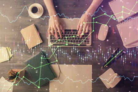 Multi exposure of woman hands working on computer and forex chart hologram drawing. Top View....