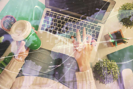 Double exposure of woman hands working on computer and forex chart hologram drawing. Top View. Financial analysis concept.の写真素材