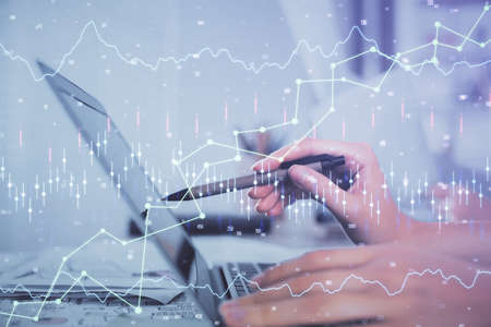 Multi exposure of woman hands typing on computer and financial graph hologram drawing. Stock market...