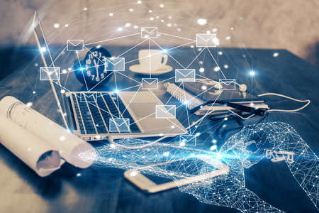 Desktop computer background in office and flying envelops hologram drawing. Double exposure....
