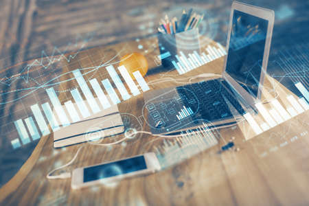 Stock market chart hologram drawn on personal computer background. Double exposure. Concept of...