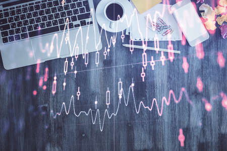 Financial market graph and top view computer on the desktop background. Double exposure. Investment concept.の写真素材