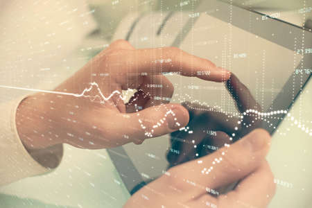 Multi exposure of mans hands holding and using a phone and financial chart drawing. Market analysis...
