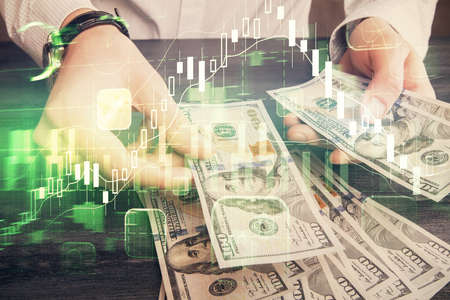 Multi exposure of financial graph drawing hologram and USA dollars bills and man hands. Analysis...