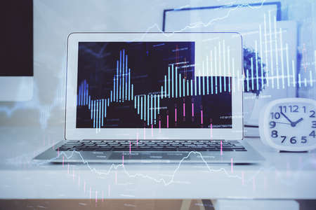 Forex market chart hologram and personal computer background. Double exposure. Concept of...