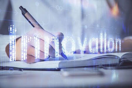 Multi exposure of womans writing hand on background with data technology hologram. Concept of innovation.の写真素材