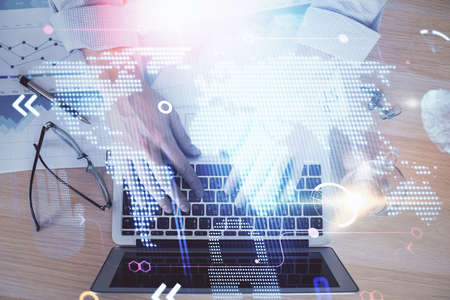 Multi exposure of world map hologram with man working on computer on background. Concept of...