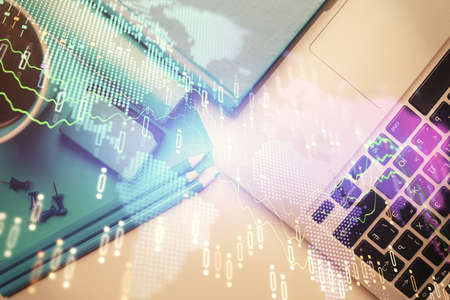 Double exposure of forex graph drawing over desktop background with computer. Concept of financial...