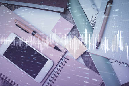 Multi exposure of forex graph hologram over desktop with phone. Top view. Mobile trade platform...