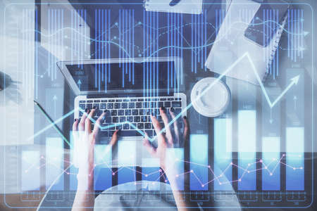 Double exposure of woman hands working on computer and forex chart hologram drawing. Top View....