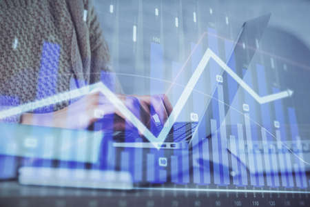 Double exposure of woman hands typing on computer and forex chart hologram drawing. Stock market analysis concept.の写真素材