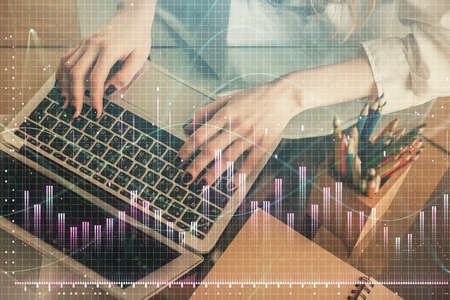 Double exposure of woman hands typing on computer and forex chart hologram drawing. Stock market...