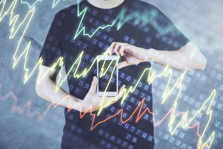 Double exposure of mans hands holding and using a digital device and forex graph drawing. Financial...