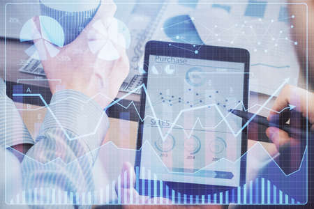 Double exposure of mans hands holding and using a phone and financial chart drawing. Market analysis...