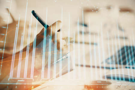 Double exposure of forex chart drawing over people taking notes background. Concept of financial analysisの写真素材