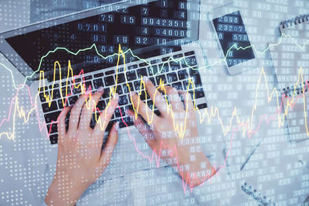 Double exposure of woman hands working on computer and forex chart hologram drawing. Top View....