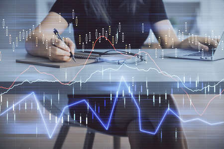 Double exposure of businesswoman hands typing on computer and forex chart hologram drawing....