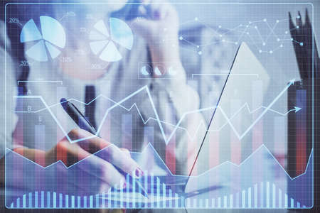 Double exposure of woman hands typing on computer and financial graph hologram drawing. Stock market...