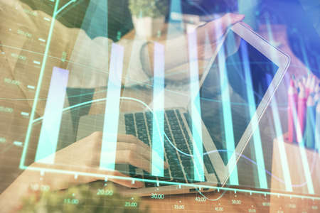 Double exposure of woman hands typing on computer and forex chart hologram drawing. Stock market invest concept.の写真素材