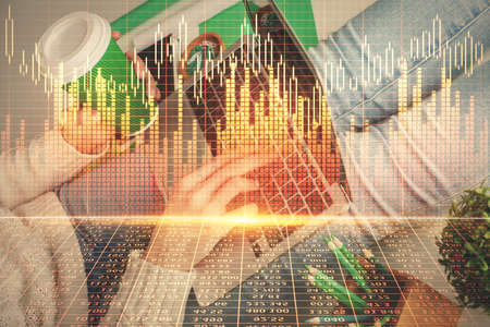 Double exposure of woman hands typing on computer and forex chart hologram drawing. Stock market...