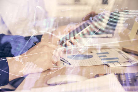 Double exposure of mans hands holding and using a digital device and forex graph drawing. Financial market concept.の写真素材