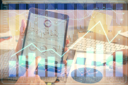 Multi exposure of mans hands holding and using a phone and financial chart drawing. Market analysis...