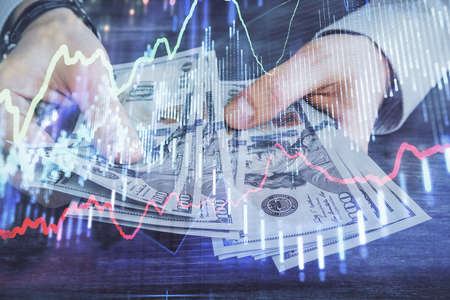 Multi exposure of financial graph drawing hologram and USA dollars bills and man hands. Analysis...