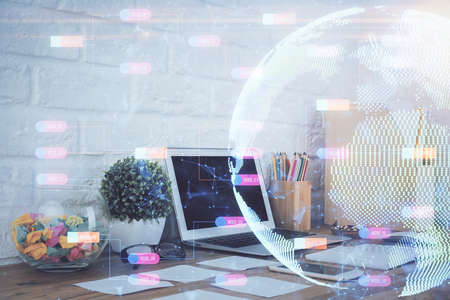 Double exposure of desktop with computer and world map hologram. International data network concept.