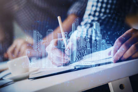 Abstract holographic city on mans hand writing notes background. Double exposure.の写真素材