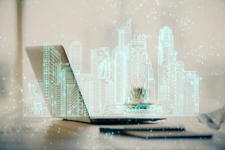 Desktop computer background in office and big town buildings hologram drawing. Double exposure. Smart city concept.の写真素材
