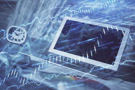 Financial graph colorful drawing and table with computer on background. Multi exposure. Concept of international markets.の写真素材
