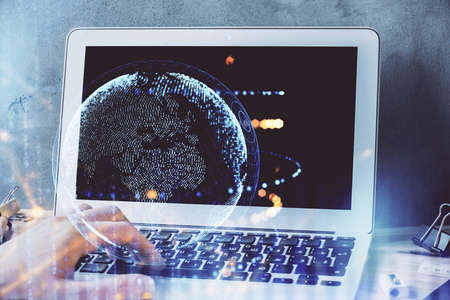 Double exposure of world map hologram with man working on computer on background. Concept of worldwideweb.の写真素材