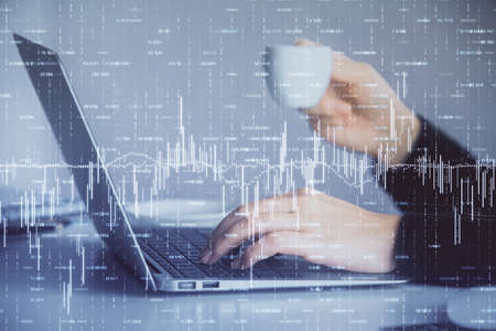 Double exposure of businesswoman hands typing on computer and forex graph hologram drawing....