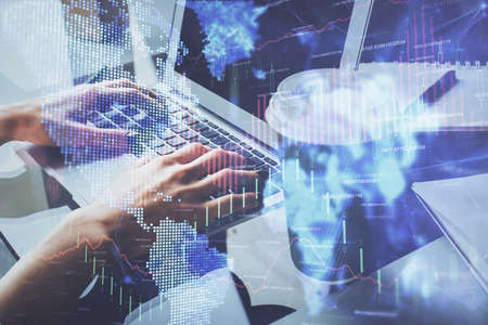 Double exposure of woman hands typing on computer and forex chart hologram drawing. Stock market invest concept.の写真素材