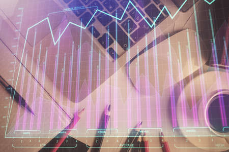 Double exposure of financial chart drawing over table background with computer. Concept of research...