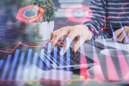 Double exposure of woman hands typing on computer and forex chart hologram drawing. Stock market...