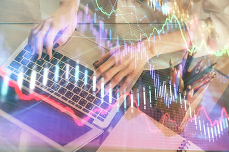 Double exposure of woman hands typing on computer and forex chart hologram drawing. Stock market...