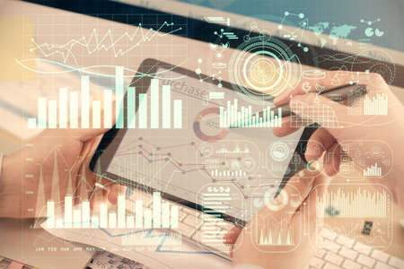 Double exposure of mans hands holding and using a phone and financial chart drawing. Market analysis...