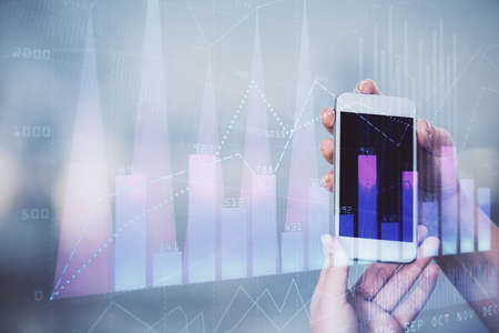 Double exposure of forex graph sketch hologram and woman holding and using a mobile device. Stock market concept.の写真素材