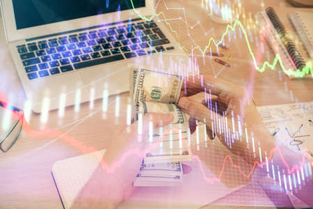 Multi exposure of financial graph drawing hologram and USA dollars bills and man hands. Analysis...
