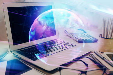 Computer on desktop in office with technology theme hologram. Double exposure. Tech concept.の写真素材