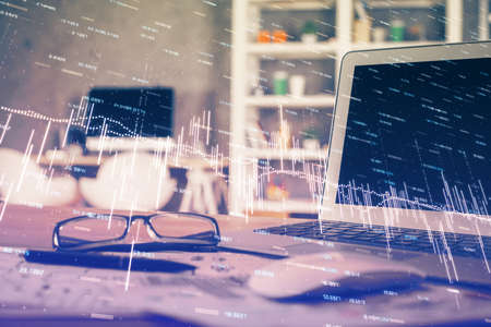 Double exposure of chart and financial info and work space with computer background. Concept of...