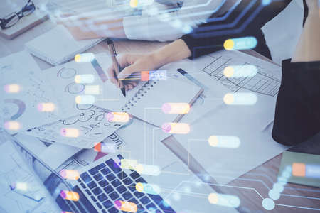 Double exposure of womans writing hand on background with data technology hud. Big data concept.