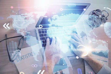 Multi exposure of world map hologram with man working on computer on background. Concept of...