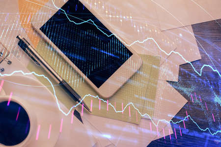 Multi exposure of forex graph hologram over desktop with phone. Top view. Mobile trade platform...