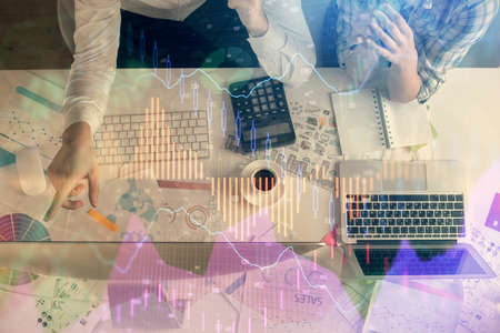 Double exposure of man and woman working together and financial chart hologram drawing. market analysis concept. Computer background. Top View.の写真素材