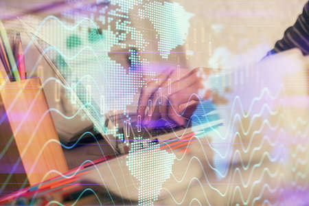 Double exposure of woman hands typing on computer and forex chart hologram drawing. Stock market...