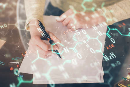 Science formula hologram over womans hands taking notes background. Concept of study. Multi exposureの写真素材