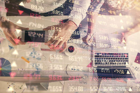 Double exposure of man and woman working together and financial chart hologram drawing. market analysis concept. Computer background. Top View.の写真素材