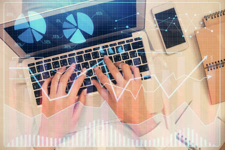 Double exposure of woman hands working on computer and forex chart hologram drawing. Top View....
